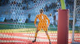 a goalie guards a net on a soccer field