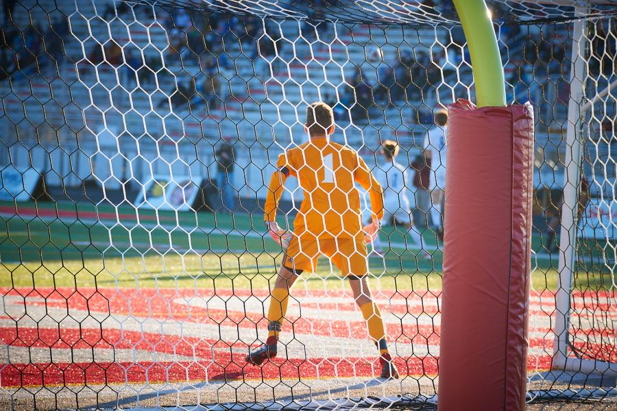 a goalie guards a net on a soccer field